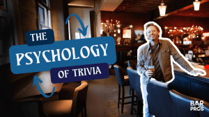 Adam holding a drink inside a warm, lively bar with text reading “The Psychology of Trivia.”